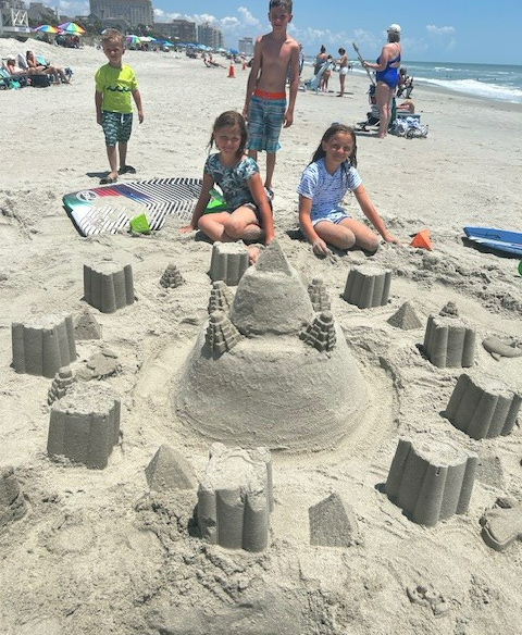 Group of smiling people in white shirts dining together at a restaurant.